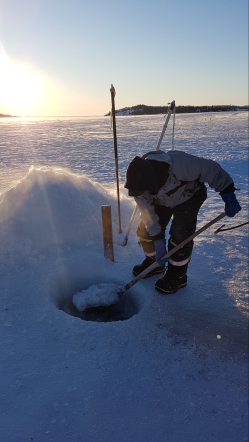 Our guide, William, demonstrating how to make a hole for ice fishing.